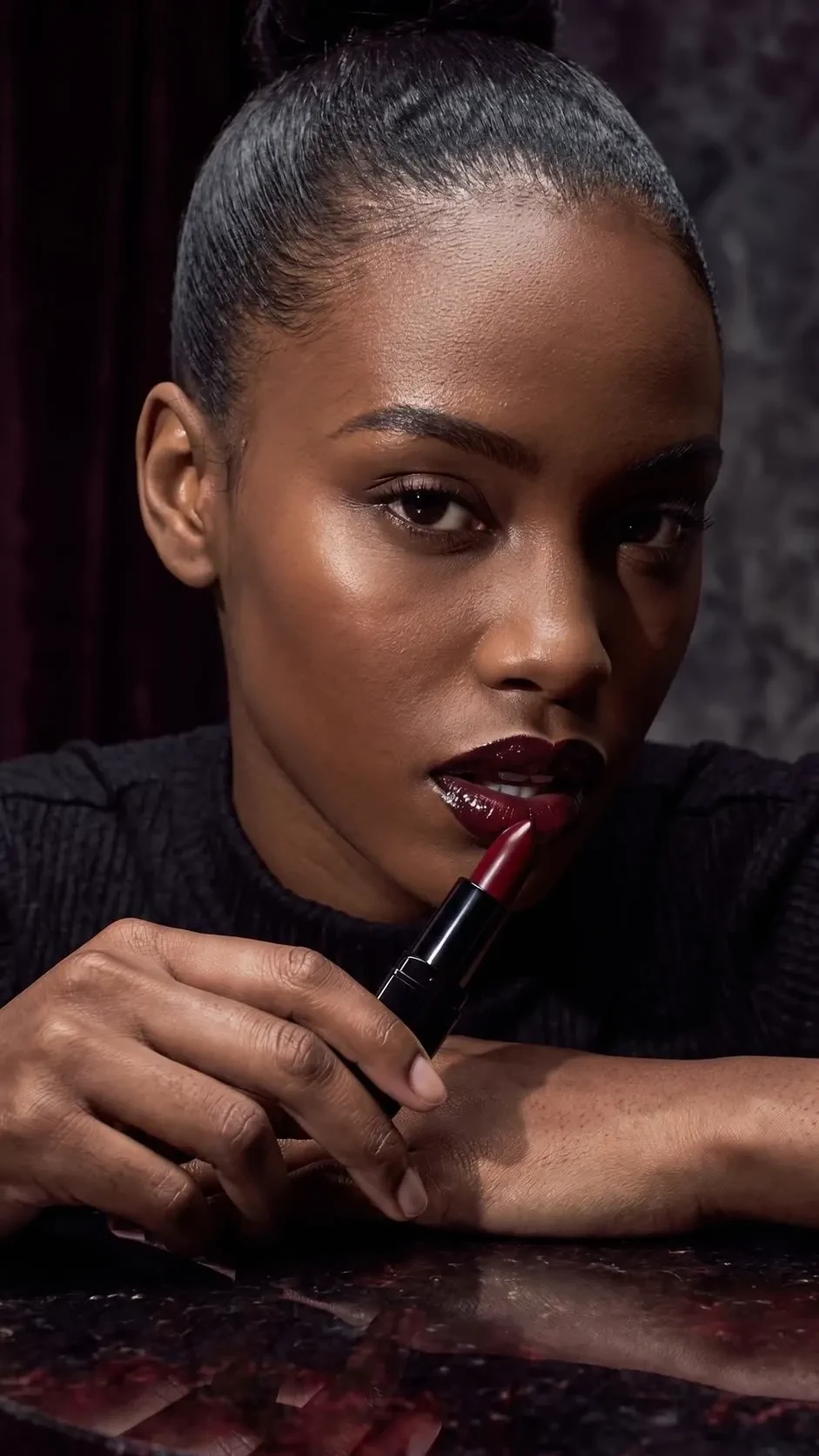 Campaign hero. Black-cherry lipstick on obsidian stone. Campaign Premiere.